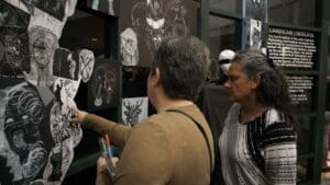 Visitors looking at and discussing artwork from the Open Scene Landslide event. 